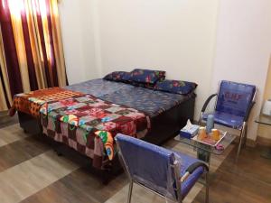 a bedroom with a bed and a chair and a table at Yog Bhawan Centre For Dance Yog Music in Greater Noida
