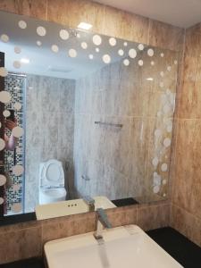 a bathroom with a sink and a toilet and a mirror at Grand Avenue Residence 1 bedroom in Pattaya Central