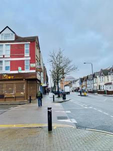 a person walking down a street in a town at Quiet cosy rooms in Harrow