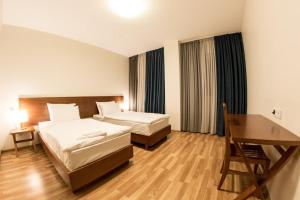 a hotel room with two beds and a desk at Hotel Deka in Gudauri