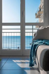 a bedroom with a view of the ocean through windows at Babyaccommodation Family Experience in Pietra Ligure