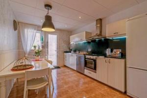 a kitchen with white cabinets and a table and a counter at Chalet Santa Susana in Santa Susanna