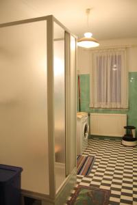 a bathroom with a refrigerator and a tiled floor at Nostalgie Apartments Titz in Vienna