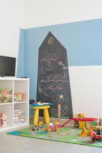 a room with a chalkboard with a table and toys at Babyaccommodation Family Experience in Pietra Ligure