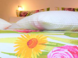a bed with a white pillow and a flower on it at Ferienwohnung ADMIRAL in Kühlungsborn
