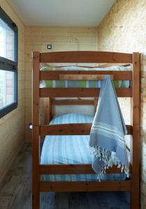 - un lit superposé dans une cabine avec une serviette bleue dans l'établissement Au courtil des chênes marins, meublé 3 étoiles, à Digosville