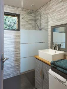 La salle de bains est pourvue d'un lavabo et d'un miroir. dans l'établissement Au courtil des chênes marins, meublé 3 étoiles, à Digosville
