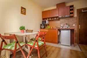 a kitchen with a table and chairs and a refrigerator at Green Orange Apartment in Bansko