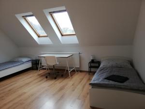 1 dormitorio con 1 cama y escritorio con tragaluces en Ubytování v podkroví, en Jeseník