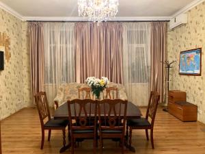 Apartment on Zhukovskogo في أوديسا: غرفة طعام مع طاولة مع الزهور عليها