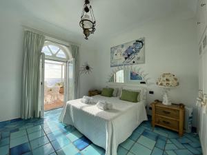 sypialnia z łóżkiem i dużym oknem w obiekcie Villa Teste di Moro w mieście Capri