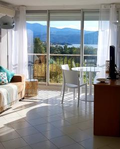 sala de estar con sofá y mesa en Saint-Florent, Agréable Studio Climatisé, Vue Panoramique Sur Le Golfe en Saint-Florent