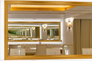 un espejo en un comedor con sillas y mesas en Hotel Galaxias, en Rodas
