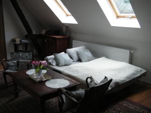 U Slunce في Ostředek: غرفة نوم بسرير وطاولة مع كراسي