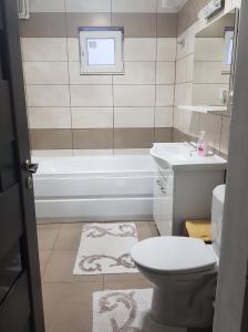 y baño con aseo, bañera y lavamanos. en Casa ABP, en Vatra Dornei