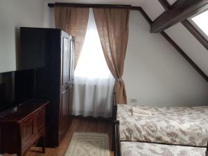 1 dormitorio con cama y ventana en Casa ABP, en Vatra Dornei
