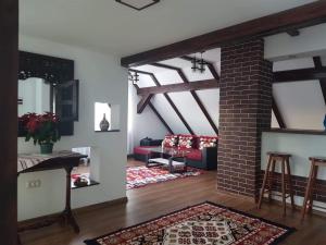 sala de estar con sofá rojo y chimenea de ladrillo en Casa ABP, en Vatra Dornei