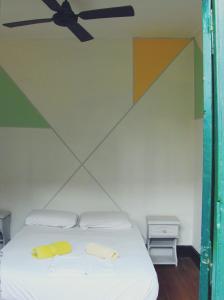 um quarto com uma cama e uma ventoinha de tecto em Freedom Hostel em Rosário