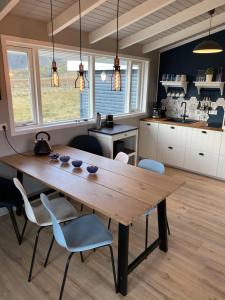 a kitchen with a wooden table and chairs at Nátthagi Luxury Cottage in Snæfellsbær
