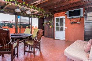 a dining room with a table and chairs and a tv at casa orymar in El Cotillo