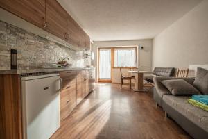 a kitchen and living room with a couch and a table at Residencesora in San Vigilio Di Marebbe