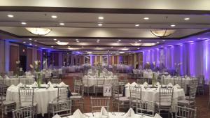 a banquet hall with white tables and chairs and purple lighting at Holiday Inn Miami West - Airport Area by IHG in Hialeah Gardens +37 photos