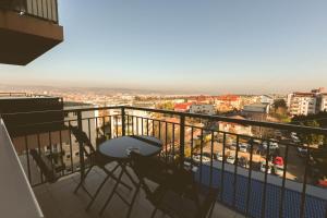 a balcony with two chairs and a view of a city at Zorilor View Apartment in Cluj-Napoca
