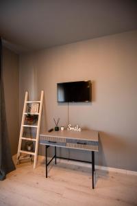 a desk in a room with a tv on a wall at Zorilor View Apartment in Cluj-Napoca