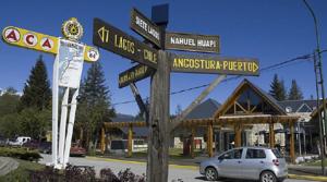 un cartello stradale di fronte a una stazione di servizio di Hosteria ACA al Sur a Villa La Angostura