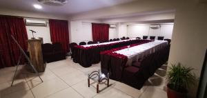 een vergaderzaal met een lange tafel met rode rozen erop bij Hotel Crown Inn in Karachi