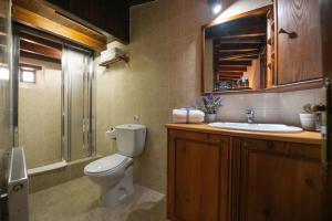 a bathroom with a toilet and a sink at Apanemia Inn House in Lofou +28 photos
