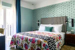 1 dormitorio con cama y pared de ladrillo en Center Chic Hotel - an Atlas Boutique Hotel, en Tel Aviv