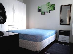 Habitación con cama en la esquina de una habitación en Excelente localização! Perto da praia com estacionamento, ar condicionado, wi-fi e Netflix!, en Balneário Camboriú