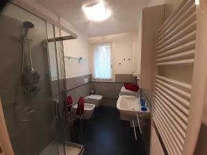 y baño con 2 aseos, lavamanos y ducha. en TraMare&Monti, en Pordenone