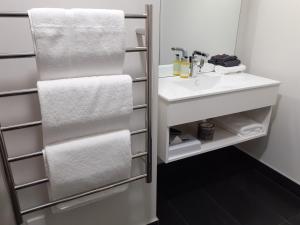 a bathroom with a white sink and towels at Kerikeri Homestead Motel & Apartments in Kerikeri