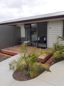 a house with a deck with a patio at Kerikeri Homestead Motel & Apartments in Kerikeri