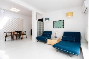 ein Wohnzimmer mit blauen Stühlen und einem Tisch in der Unterkunft Wehost Apartment With Huge Terrace in Tbilisi City