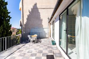 a balcony with two chairs and glass doors at Wehost Apartment With Huge Terrace in Tbilisi City