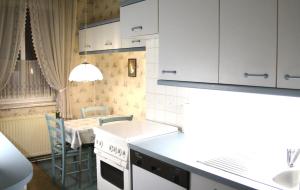 a kitchen with white cabinets and a table with a dining room at Nostalgie Apartments Titz in Vienna