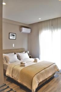 una camera da letto con un grande letto e una finestra di More Athens Apartments ad Atene