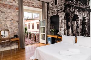 
a room with a bed, a chair and a painting on the wall at Aire Hotel & Ancient Baths in Almería
