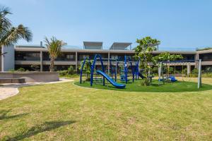 a playground in front of a large building at Pebble Beach 128 Umdloti Durban in Umdloti