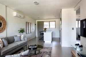 un salon avec un canapé et une table dans l'établissement Pebble Beach 128 Umdloti Durban, à Umdloti