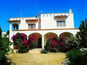 a white house with pink flowers in front of it at B&B Santa Sabina in Torre Santa Sabina