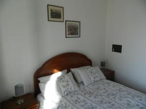 a bedroom with a bed with white sheets and pillows at Ca' d'Alfonso in Baveno