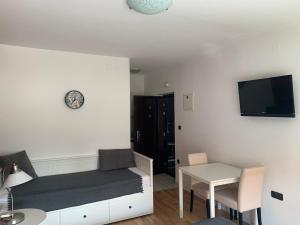 a room with a bed and a table and a tv at Celic Art Apartments in Zagreb