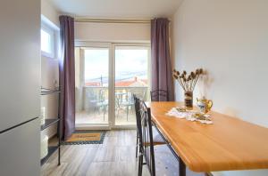 comedor con mesa y cocina con balcón en Retro Apartment, en Vrbnik