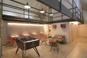 a large room with a ping pong table and chairs at Ostello dei Sassi - Matera Hostels in Matera