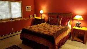 Schlafzimmer mit einem Bett mit roten Wänden und einem Fenster in der Unterkunft Cold Moon Farm B&B in Jamaica
