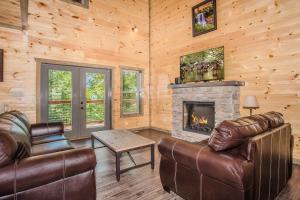 a living room with leather furniture and a fireplace at Rainwater Falls in Gatlinburg
